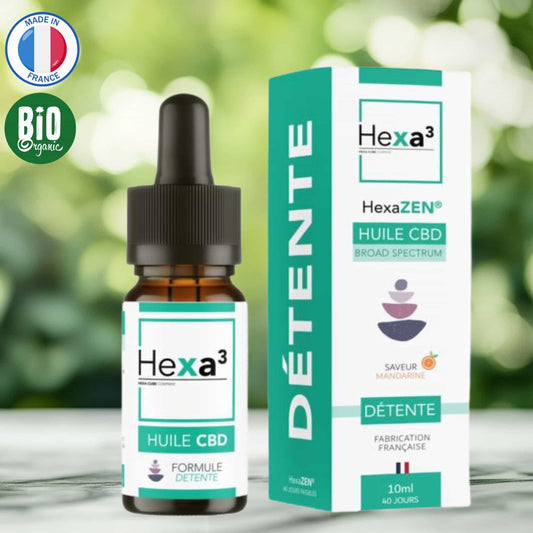 uile CBD détente bio, packaging avec flacon 10ml et boîte blanche aux accents verts, saveur mandarine. Logos Made in France et Bio en premier plan. Fond naturel vert légèrement flouté avec surface en bois clair.